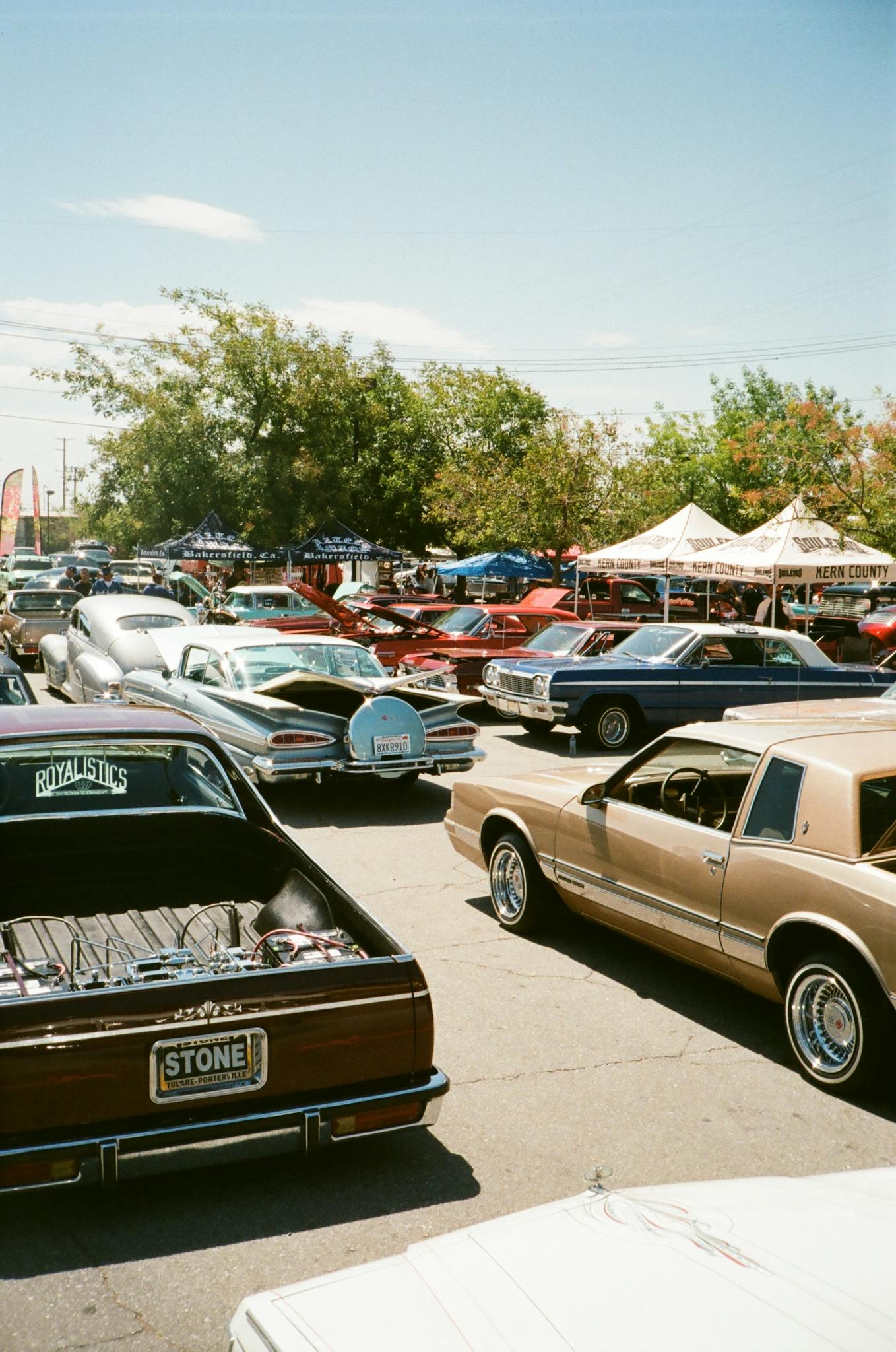 A vibrant gathering of classic cars at an outdoor show under a clear sky.